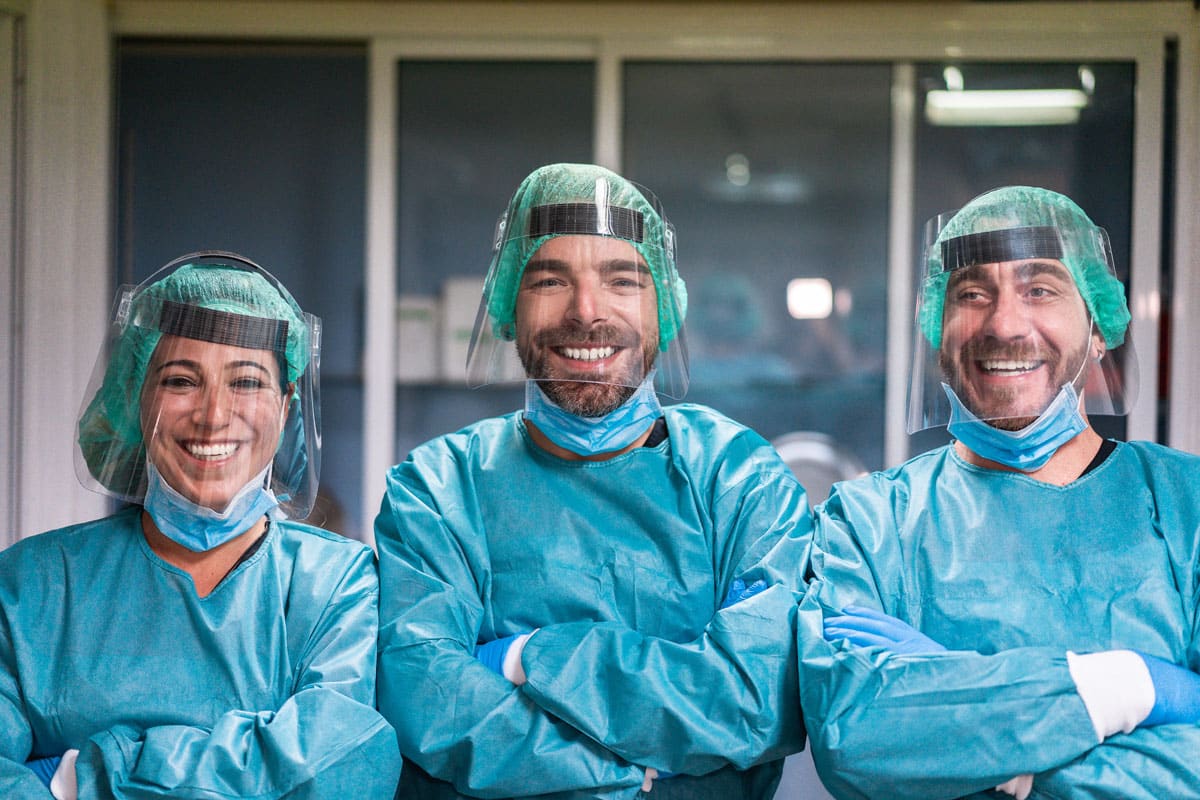 Three doctors in surgical gear representing frontline healthcare internal communications for CommsKit