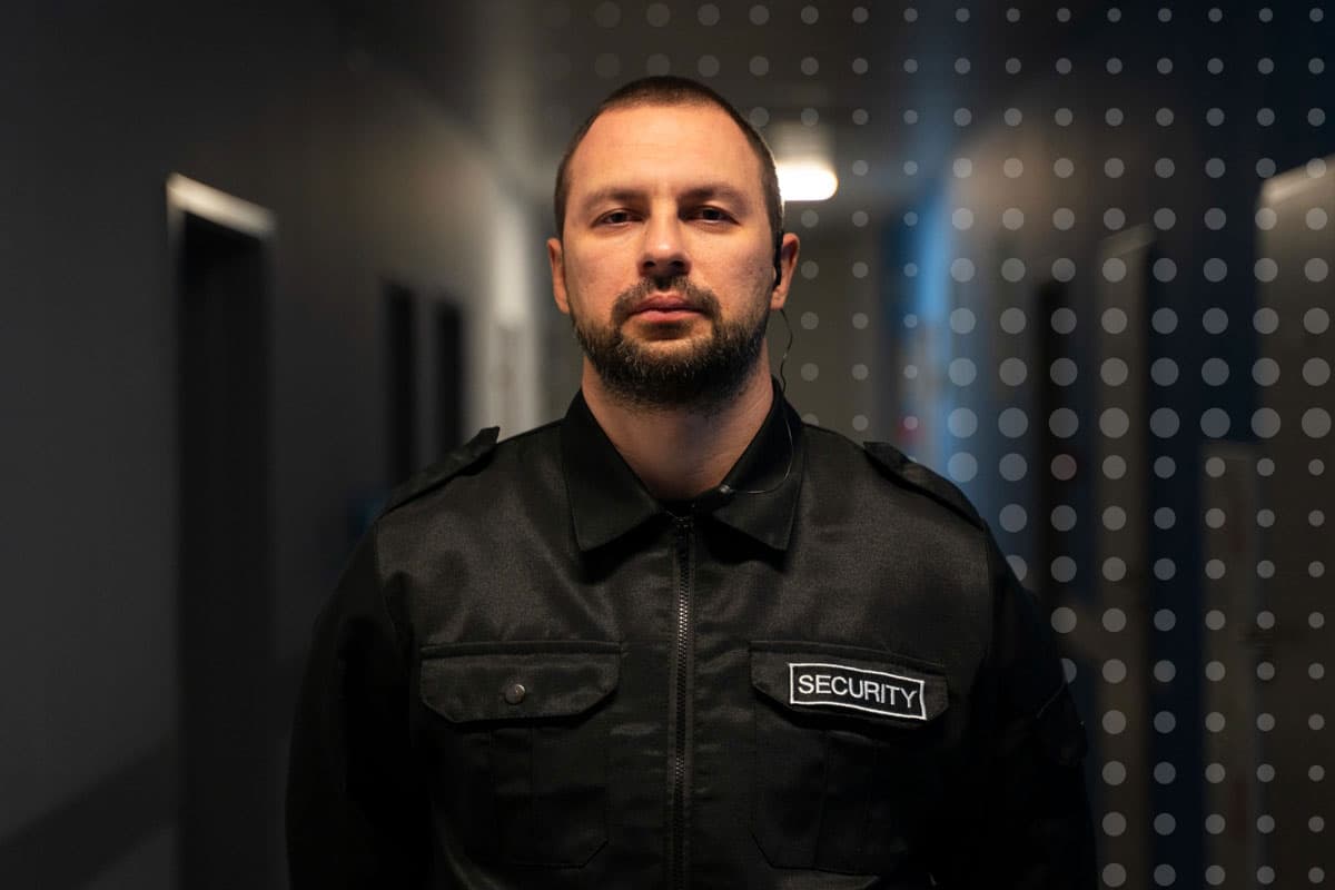 A security worker at a government defence site standing looking at the camera for employee engagement with CommsKit